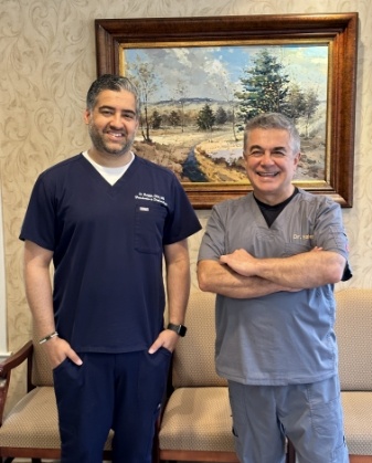 Two smiling Cranford periodontists standing in reception area of periodontal office