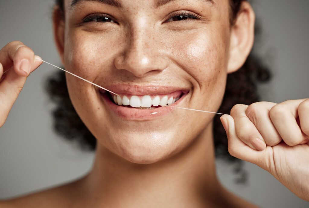 A woman flossing her teeth to prevent gingivitis